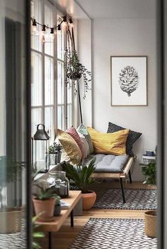 a living room filled with lots of furniture and plants on top of windowsills