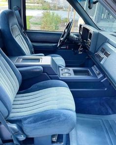 the interior of a vehicle with blue leather seats