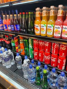 many different types of sodas on display in a store