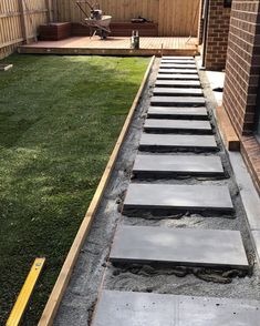 an outdoor patio with stepping stones in the middle and grass on the ground next to it