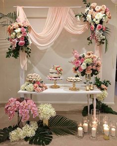 a table topped with lots of flowers and candles