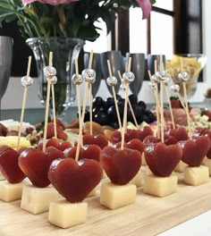 cheese and fruit are arranged on skewers with toothpicks in the shape of hearts