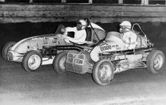 two men in race cars on a track