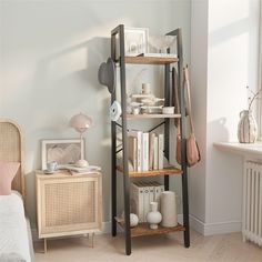 a room with a book shelf and some pictures on the wall next to a bed