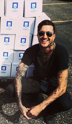 a man sitting on the ground next to stacks of boxes