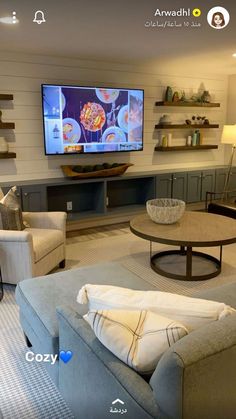 a living room filled with furniture and a flat screen tv mounted to the side of a wall