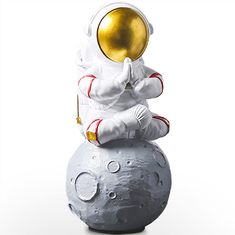 an astronaut sitting on top of a ball with a gold trophy in his hand,