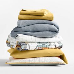 stack of folded and unmade blankets on top of each other in various shades of yellow