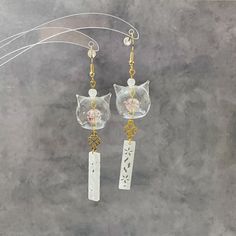 Elevate your style with these handmade earrings - an ideal blend of culture, craftsmanship, and elegance. They're perfect for any occasion!  🤍 The high-quality CAT head shaped glass charm is absolutely adorable, adorned with crackle glass bead and various stunning embellishments, you may choose to have clover charms or not, both designs are absolutely eye catching jewellery!  🤍Two colours available, completed with 18K gold-plated or 925 silver-plated, nickel-free, hypoallergenic earring hooks Chime Earrings, Good Luck Cat, Valentine Jewellery, Valentine Gifts Jewelry, Japanese Gifts, Japanese Cat, Clover Charm, Valentines Jewelry, Hypoallergenic Earrings