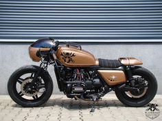 a gold and black motorcycle parked in front of a building