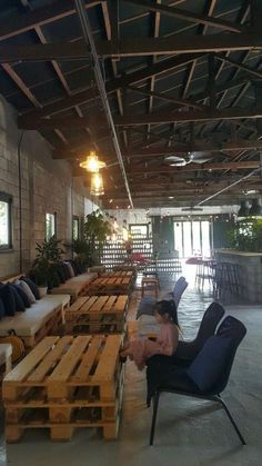 an empty restaurant with tables and chairs made out of wooden pallets