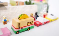 a small toy truck with a taco on the top and other toys behind it