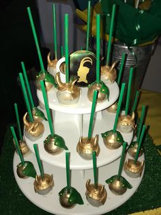 there is a cake with gold decorations on it and green candles in the shape of bells