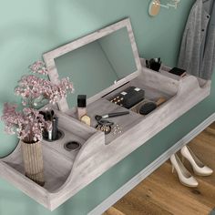 a desk with a mirror, purse and other items on it in front of a green wall