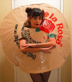 a woman standing in front of a door wearing a paper plate costume with roses on it