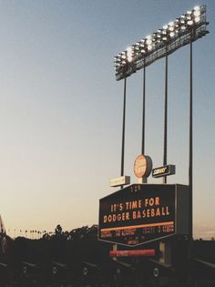 a baseball stadium sign with lights on it's top and the words it's time for dodger baseball