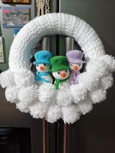 two snowmen are sitting in the middle of a wreath