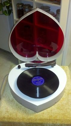 an old record player sitting on top of a rug in front of a bookcase