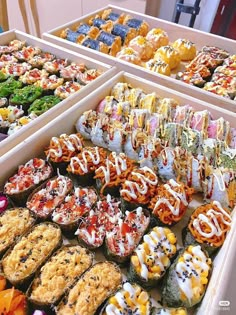 there are many different types of sushi in the trays on this table together