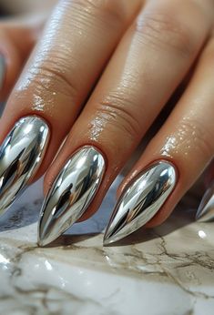 Discover the top 25 silver chrome nails for 2024, featuring the latest trends from sleek stiletto to minimalist chic. Dive into a world of lustrous, mirror-like finishes, edgy geometric patterns, and sparkling rhinestone details that define modern nail art. Embrace the elegance of almond shapes and innovative French tips that elevate your style. Perfect for fashion-forward individuals looking to make a statement. Click to unveil the future of nai Chrome Nails Silver, Silver Chrome Nails, Modern Nail Art, Festive Nail Designs, Nail Aesthetic, Aesthetic Nail, Mirror Nails, Purple Nail Designs