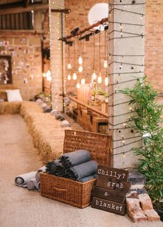 hay bales and blankets are sitting on the ground in front of a brick building