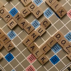 scrabble tiles spelling out the names of cities and towns on a board game