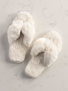 Step into comfort in Shiraleah’s Rina Slippers. This slipper features a plush texture upon a rubber bottom making them cozy, yet sturdy. The Rina slipper has an open toe thong silhouette , fulfilling your style aspirations without compromising your need for comfort. Packaged ribbon wrapped, this item makes a great gift option in addition to completing your nighttime solace. Pair with other items from Shiraleah to complete the look! Color: Ivory S/M Fits Size 6-8 Material: Polyester And Pvc Made Soft White Slippers For Relaxation, Comfy White Slippers With Textured Footbed, Comfy Soft White Slippers, Cozy White Slippers For Loungewear, Comfy White Slippers With Soft Texture, Comfortable Fluffy White Slippers, Comfortable Soft White Slippers, Cozy White Slippers With Plush Lining, White Super Soft Slippers For Loungewear