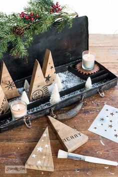 christmas decorations in an old suitcase on a wooden table with candles and other holiday items