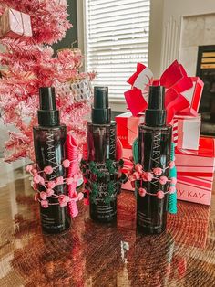 the bottles are all lined up next to each other on the table in front of the pink christmas tree