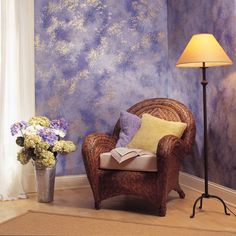 a chair and lamp in front of a blue wall with clouds painted on the walls