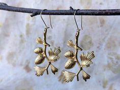 Golden brass pinecone earrings feature a beautiful pine tree branch. These bold statement earrings are perfect for any nature lover and are a gorgeous addition to any woodland wedding for brides or bridesmaids. Pine cone charms hang from gold plated ear wires and are lightweight and easy wear all day. Dimensions 3 inches high x 1.5 inches wide including ear wire My latest nature inspired jewelry line includes dainty minimalist geometric shapes with natural stones. All brass is polished to a soft Pinecone Earrings, Pine Cone Tree, Cone Trees, Earrings Nature, Paper Jewelry, Nature Inspired Jewelry, Woodland Wedding, Tree Branch, Gold Brass