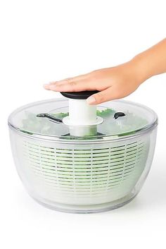 a hand is pressing the button on a food processor to press it into its bowl