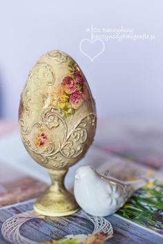 an egg sitting on top of a table next to a white bird