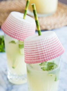 two glasses filled with drinks sitting on top of a table