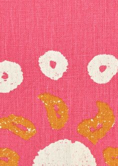 a pink background with white and gold designs on the top of it, including donuts