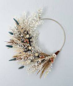 a wreath made out of dried flowers and feathers