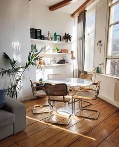 a living room filled with furniture next to a window covered in sun shining through the windows