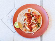 an overhead view of a taco on a red plate