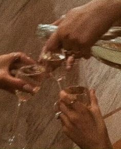 several people are holding wine glasses in their hands and toasting them with each other