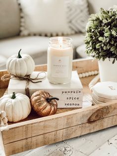 a wooden tray with candles, pumpkins and other decorative items on top of it