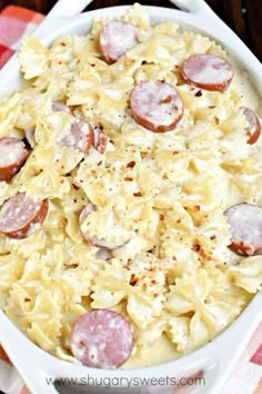 a white dish filled with pasta and sausage