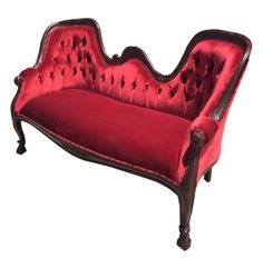 an old fashioned couch with red velvet upholstered to it's back and arms