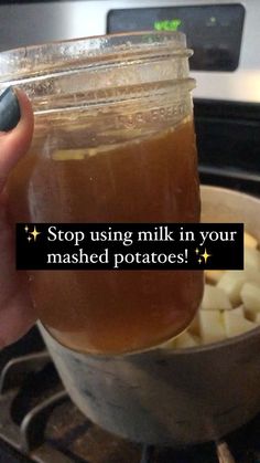 someone is holding a mason jar full of mashed potatoes in front of an oven