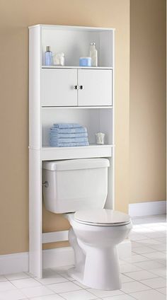 a white toilet sitting next to a shelf filled with towels