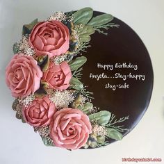 a birthday cake decorated with pink roses and greenery