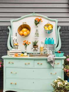 an old dresser is decorated with flowers and fruit on it's top, along with other vintage furniture