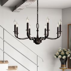 a chandelier hanging from the ceiling in a room with white walls and stairs