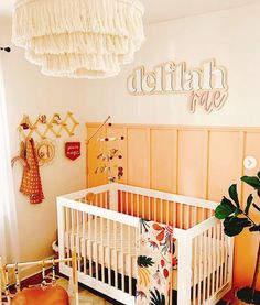 a baby's room with a white crib and wooden paneling on the wall