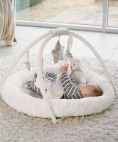 a baby laying on top of a white bed