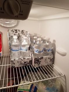 an open refrigerator filled with water and bottled drinks